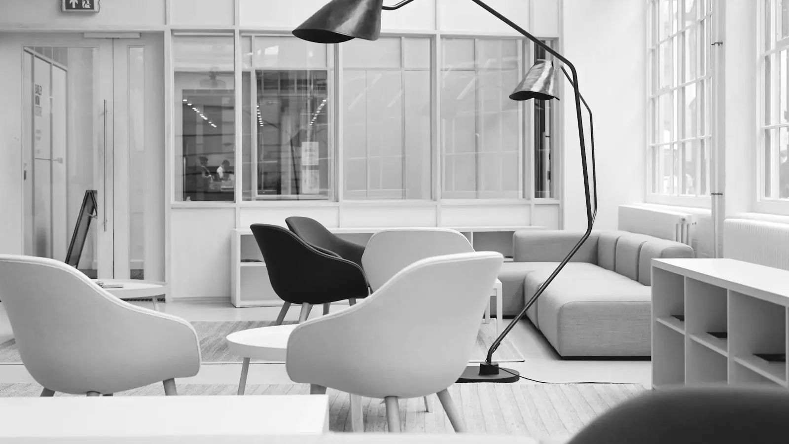 Lichte kantoorruimte met zitplaatsen rond een lage tafel en een staande lamp